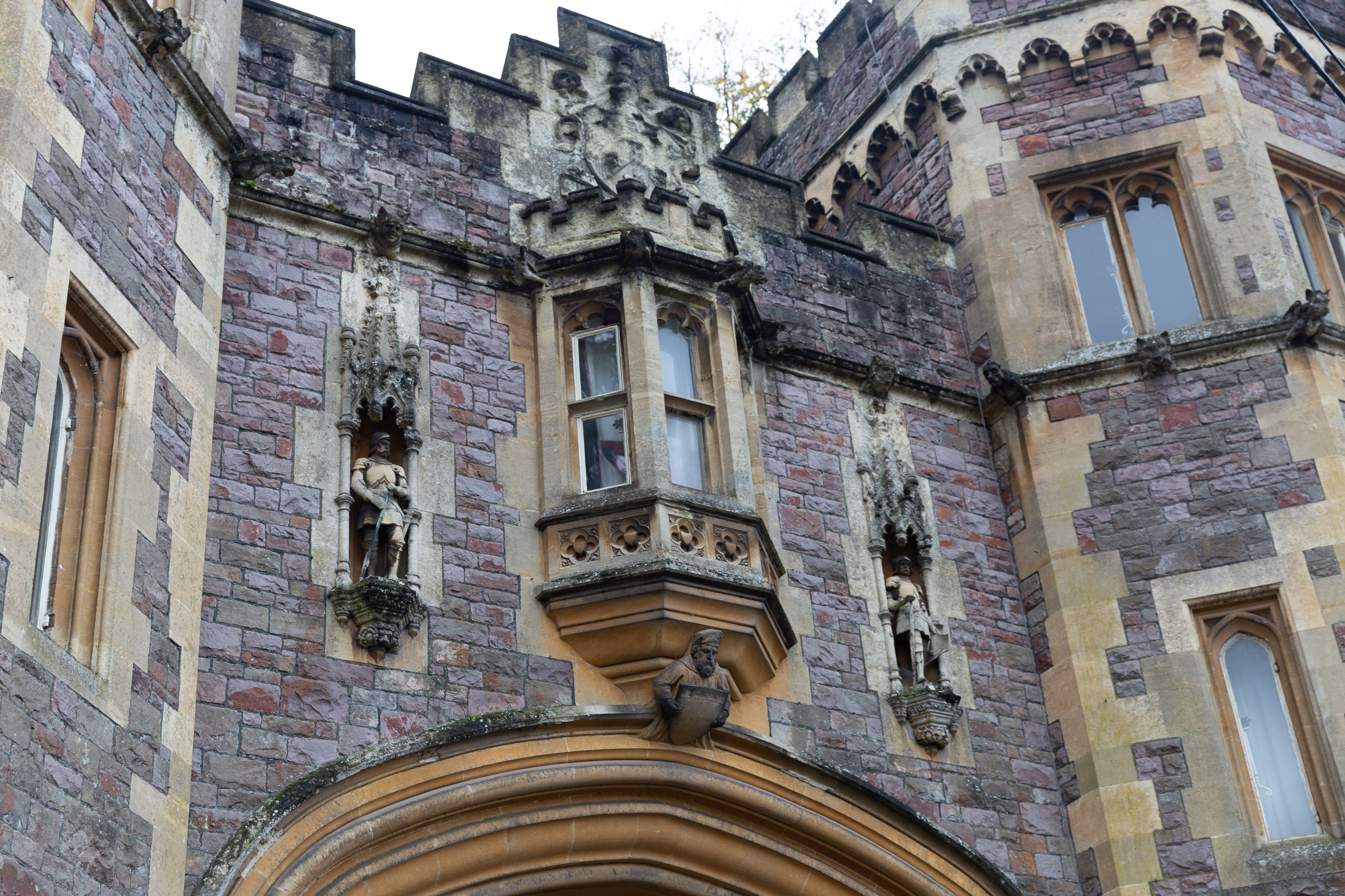 Knights
"above is a 3-light oriel with cusped tracery and flanking niches with statues of knights"
