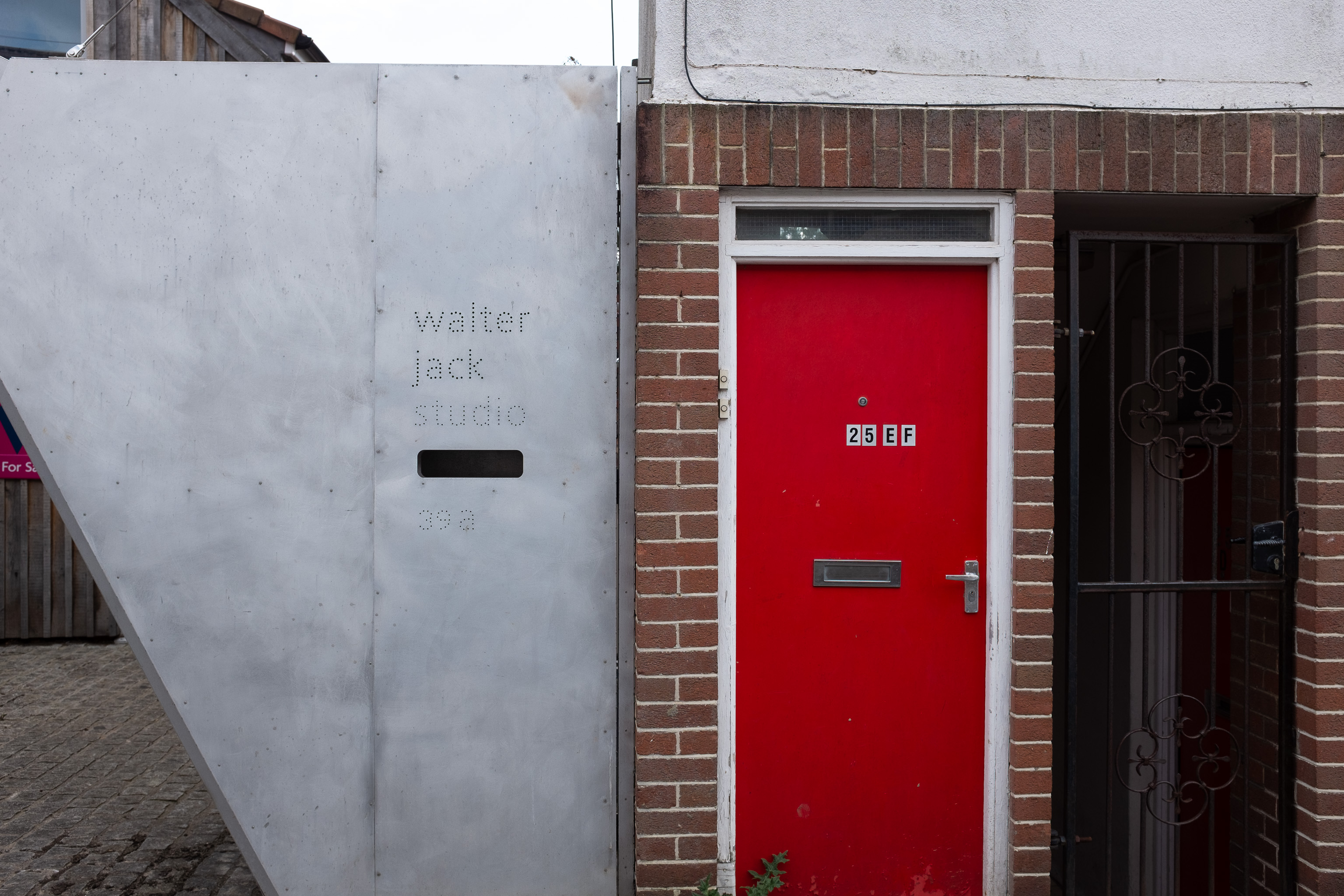 Three Very Different Doors
25 E F. It's either two flats or a very strange bra size.

Walter Jack Studio are apparently "makers of things", so that clears that up.
